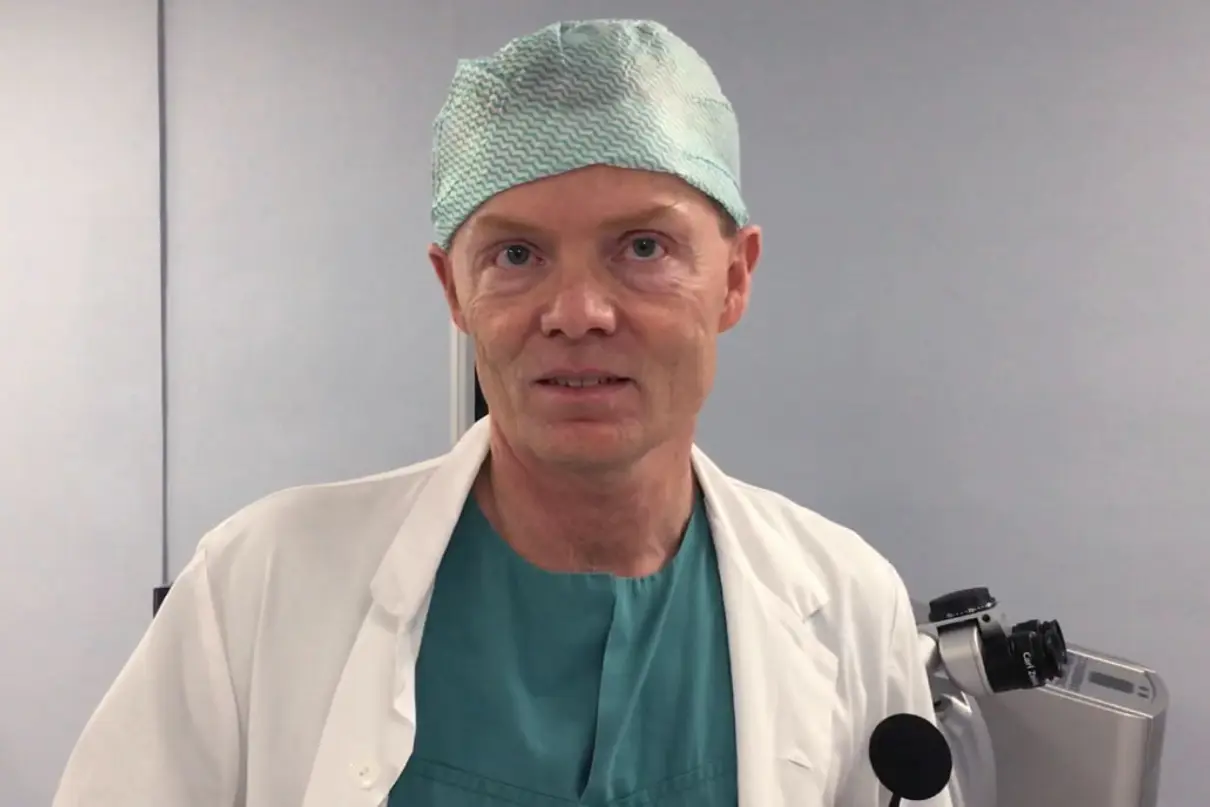 Portrett av lege med legefrakk og lue