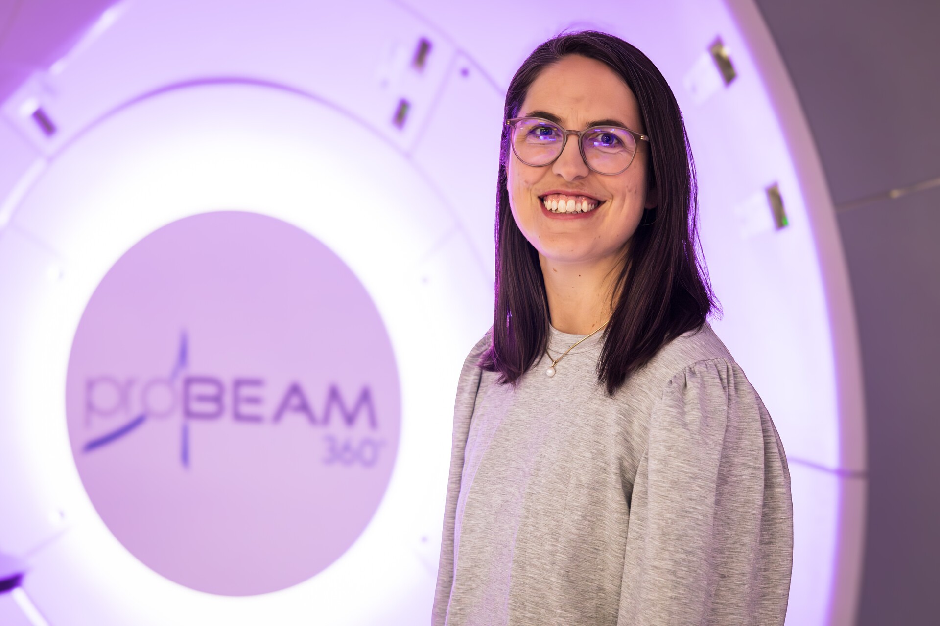 En kvinne som smiler foran et skilt