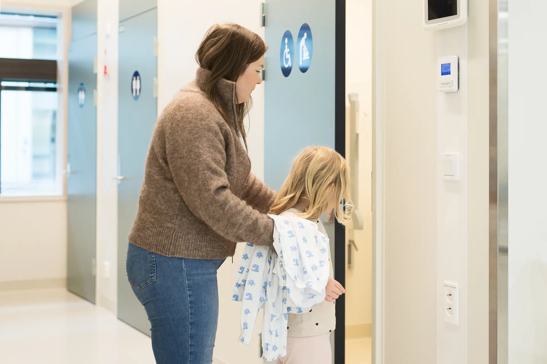 En voksen og et barn på vei inn en dør