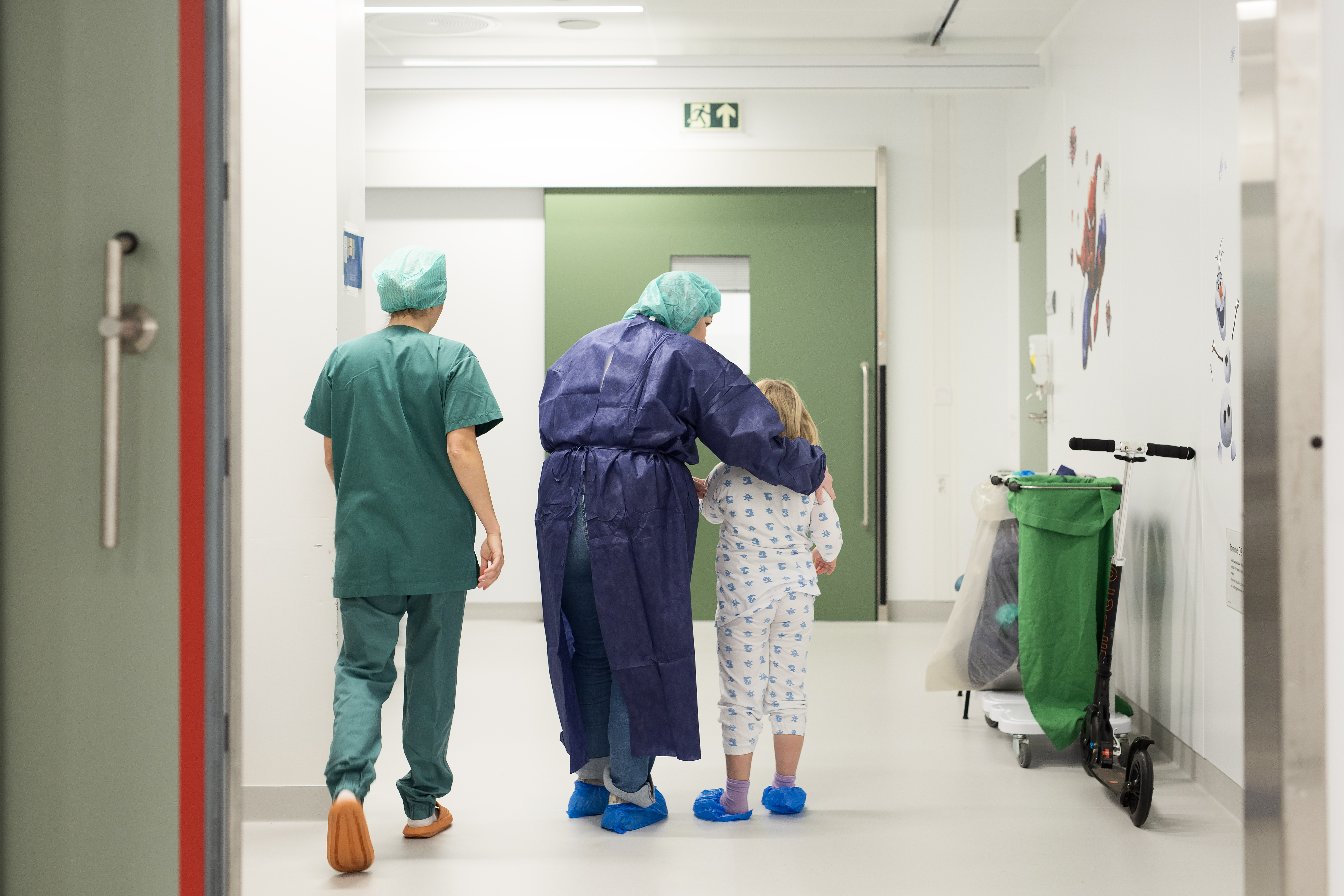 To voksne i sykehusklær sammen med et barn