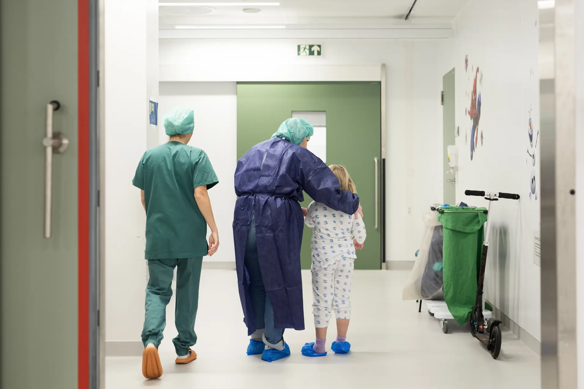 To voksne i sykehusklær sammen med et barn