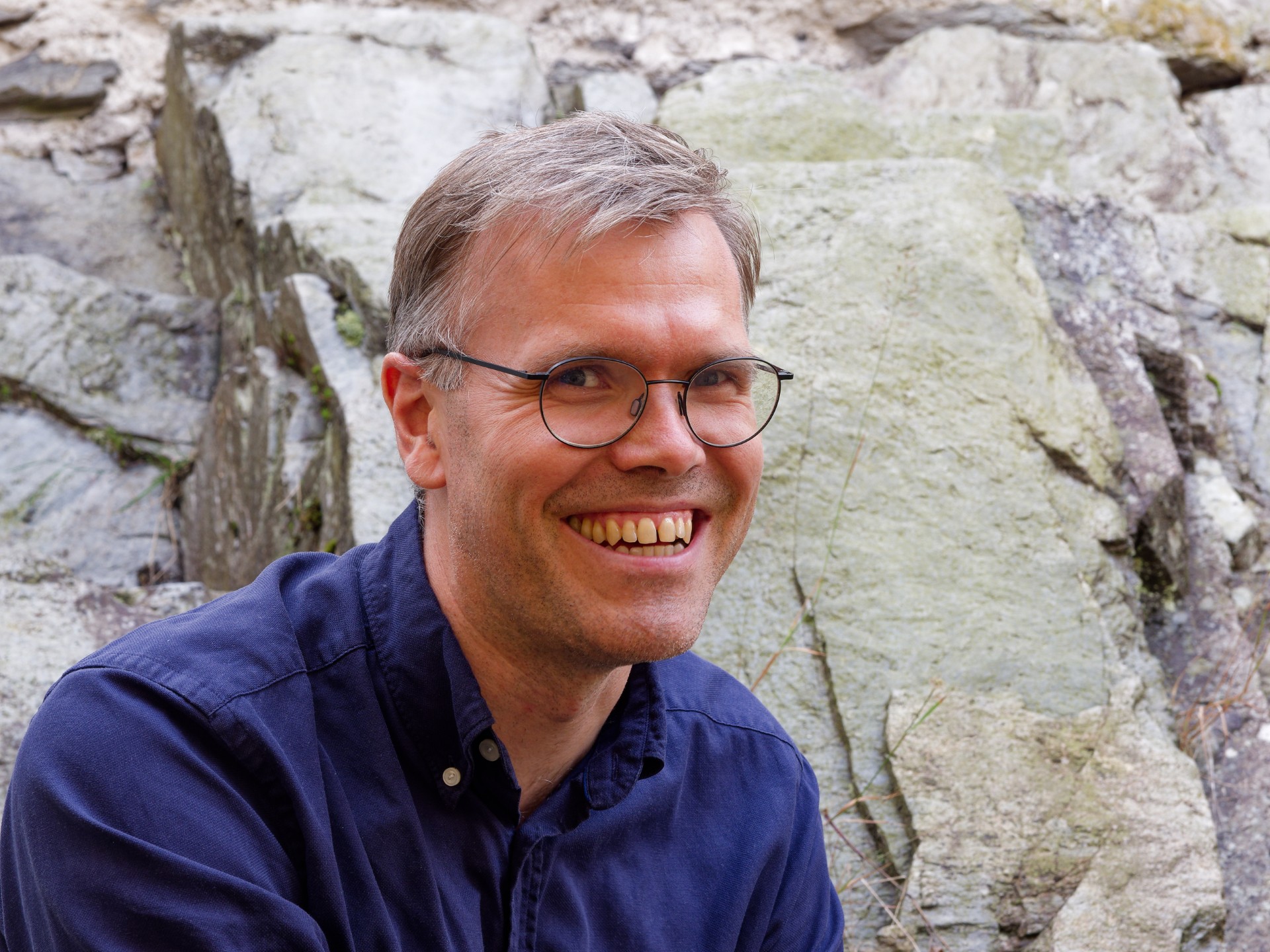 En mann som smiler til kameraet