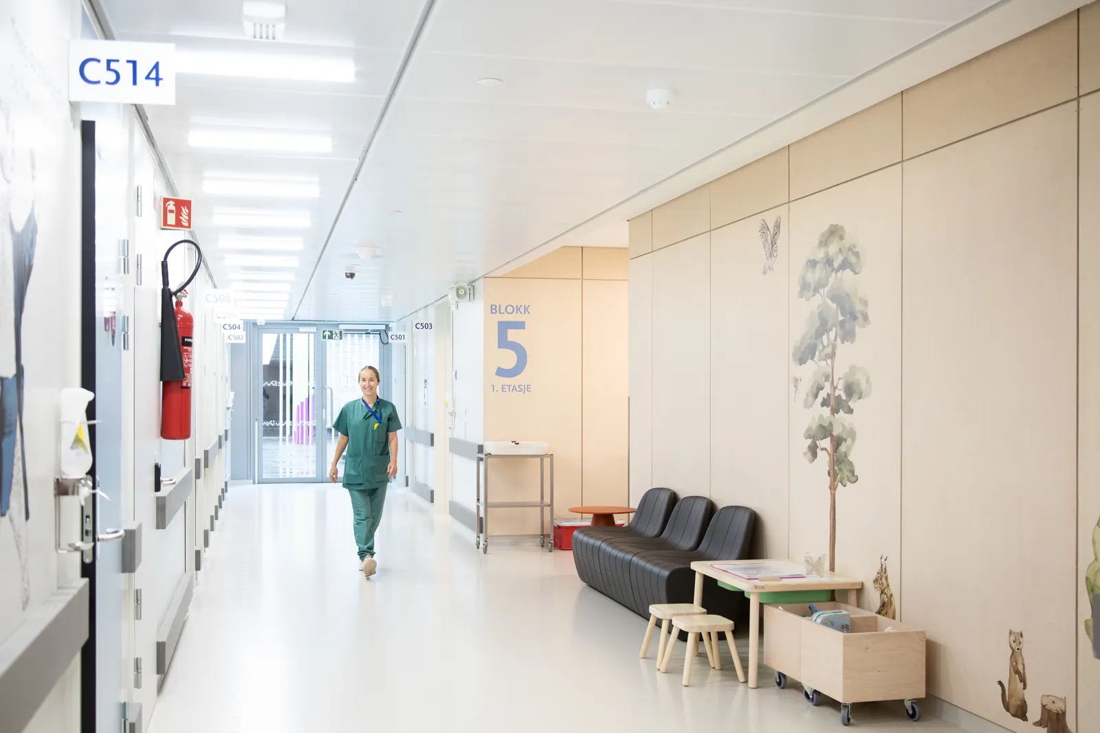 En person i sykehusklær går i en korridor