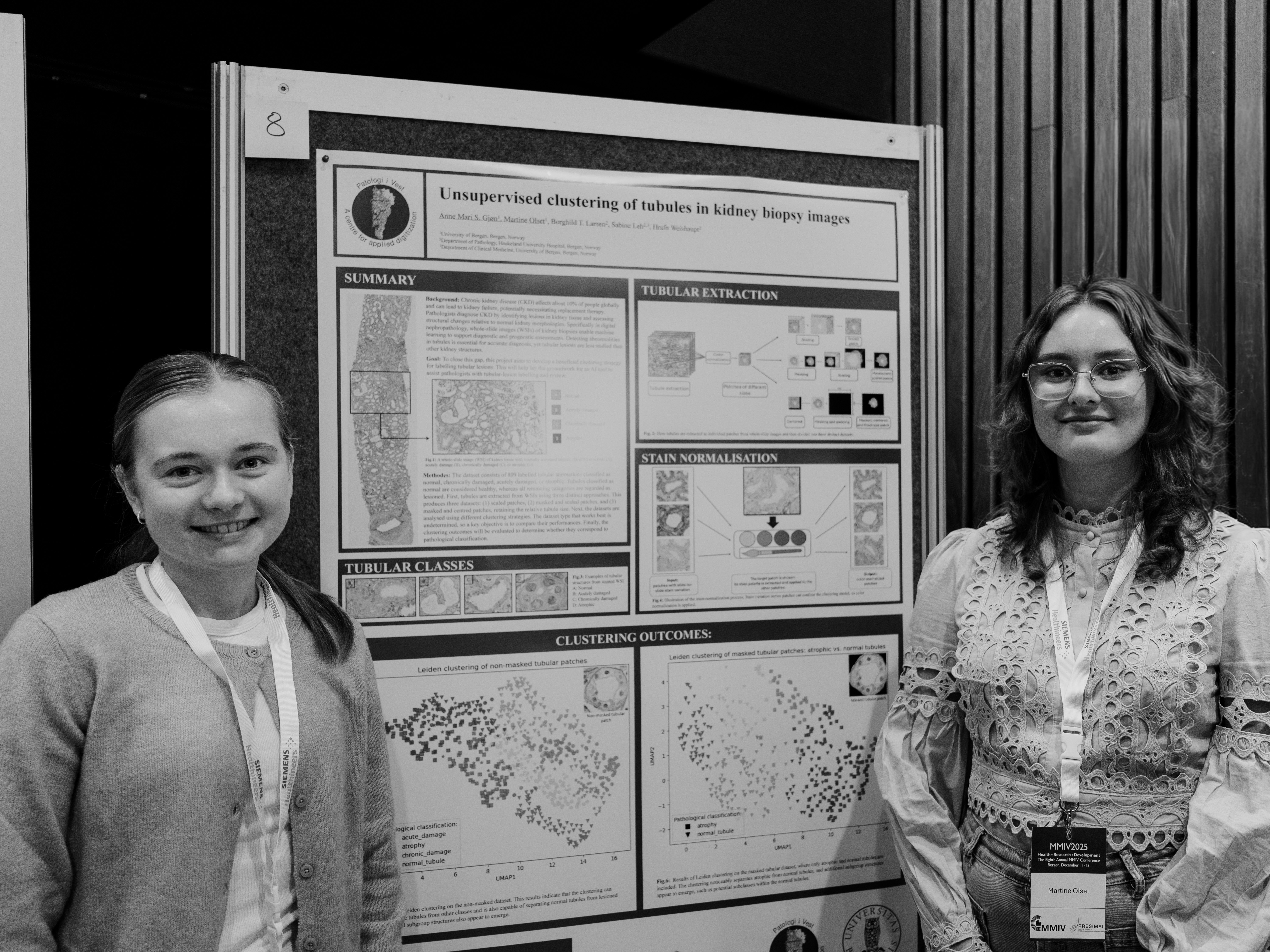 To som står foran plakat.