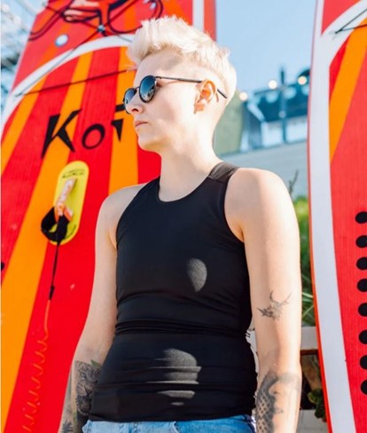 En person står foran et surfebrett