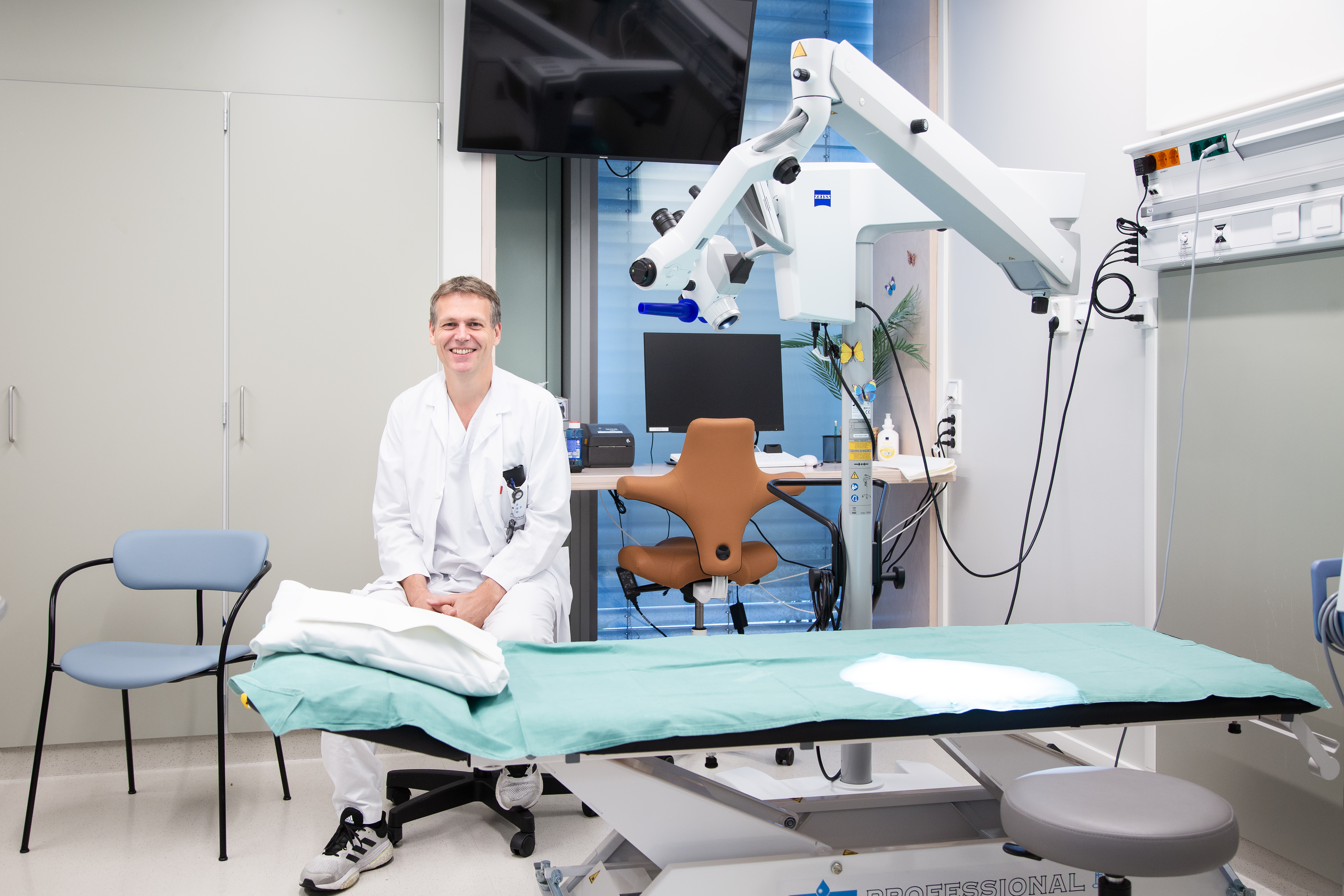 En mann sitter ved en undersøkelsesbenk