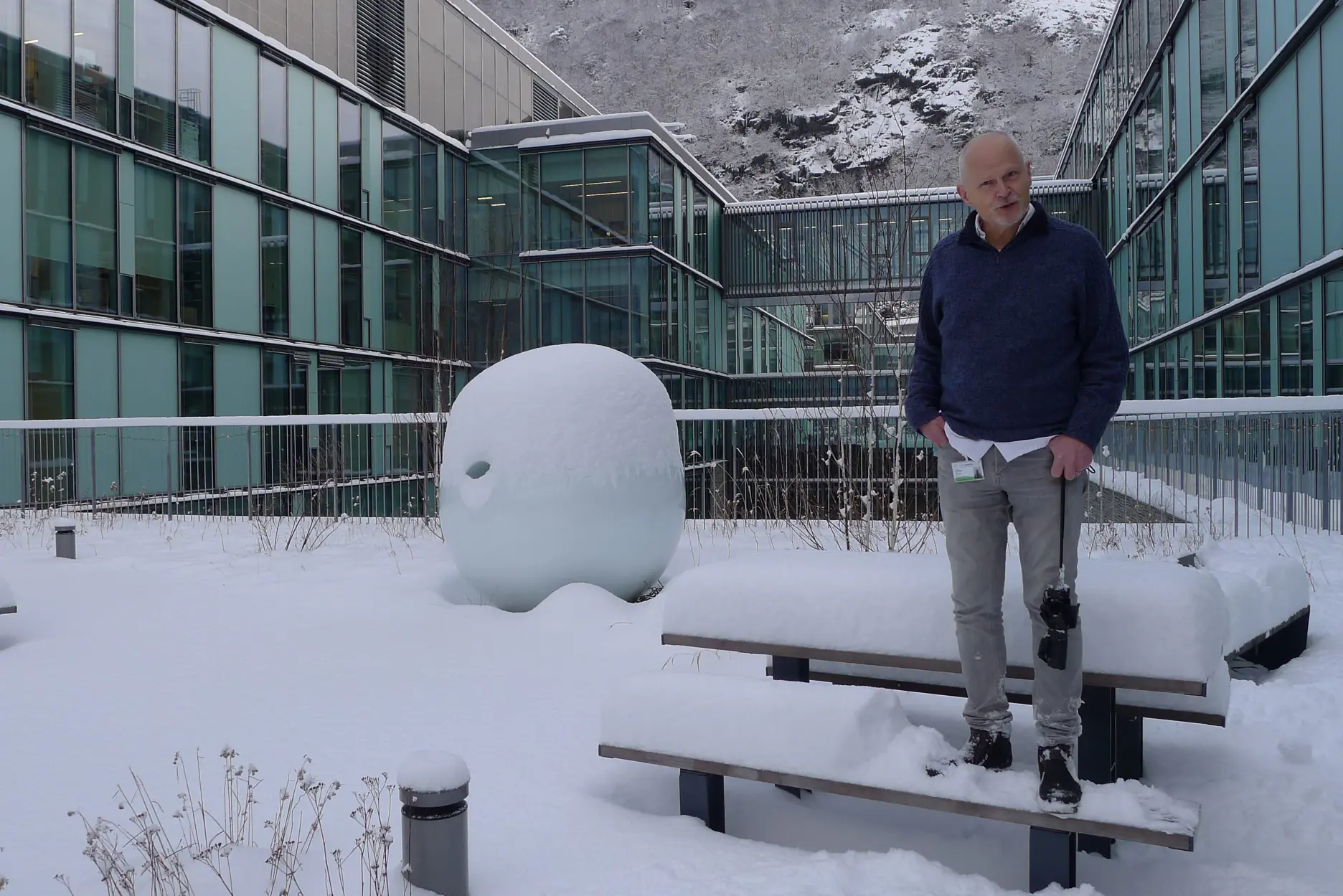 En mann som står ved siden av en snømann