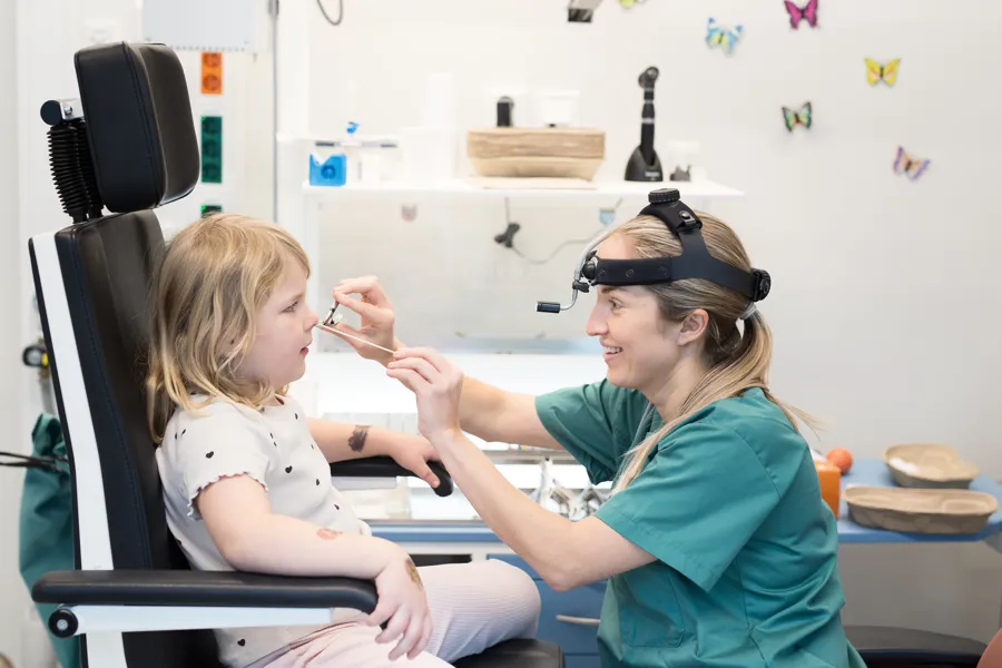 En person undersøker nesen til et barn