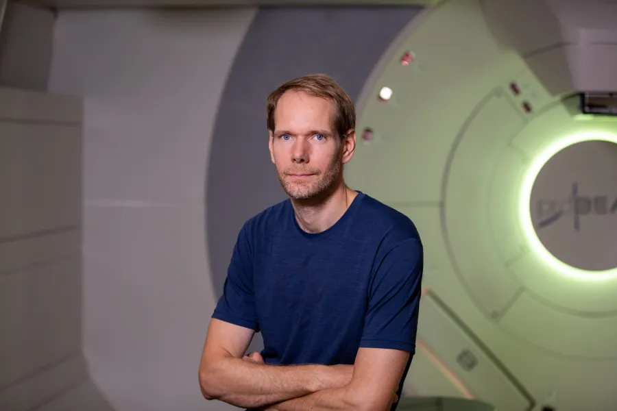 En mann som står foran en protonmaskin