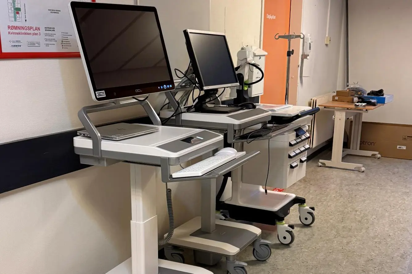 Et rom med skrivebord og datamaskin