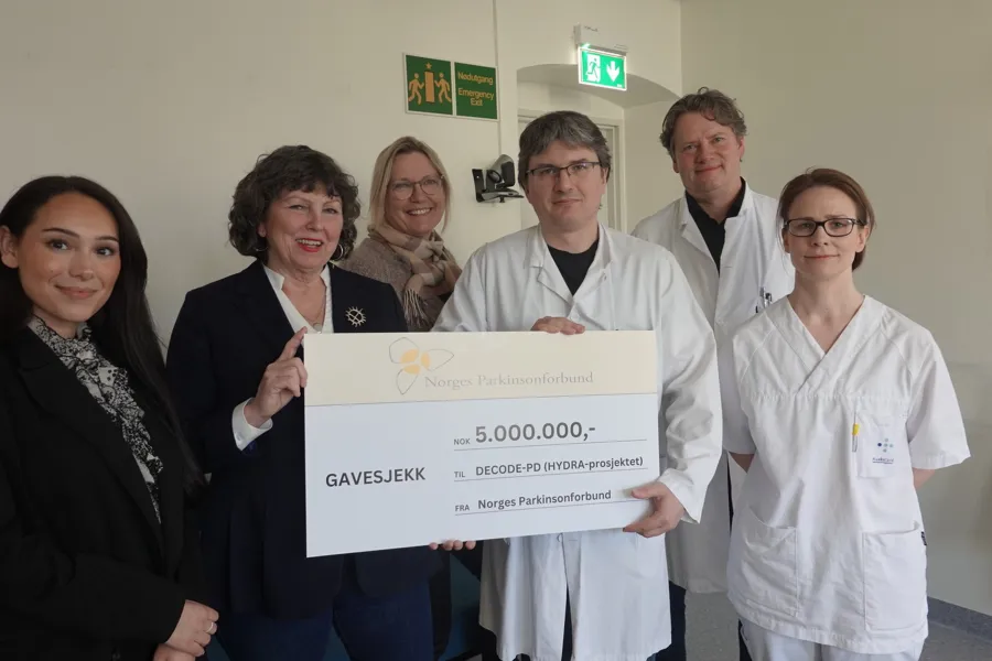 En gruppe mennesker som holder et skilt