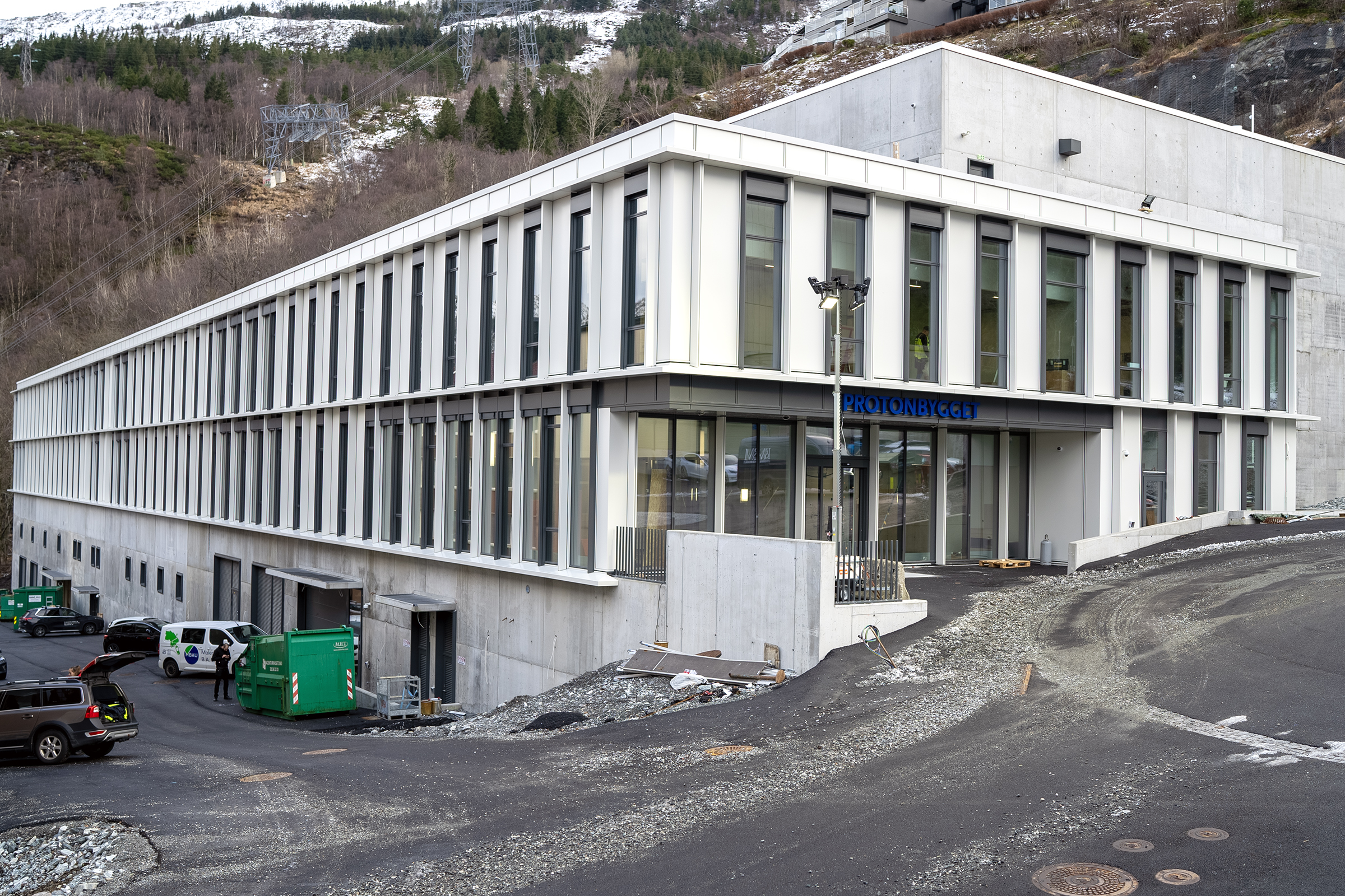 En hvit bygning med parkeringsplass