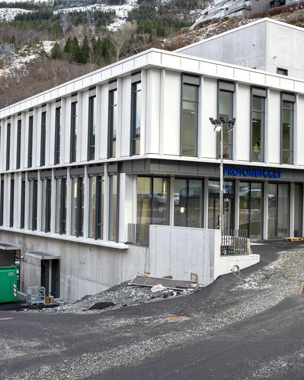 En hvit bygning med parkeringsplass