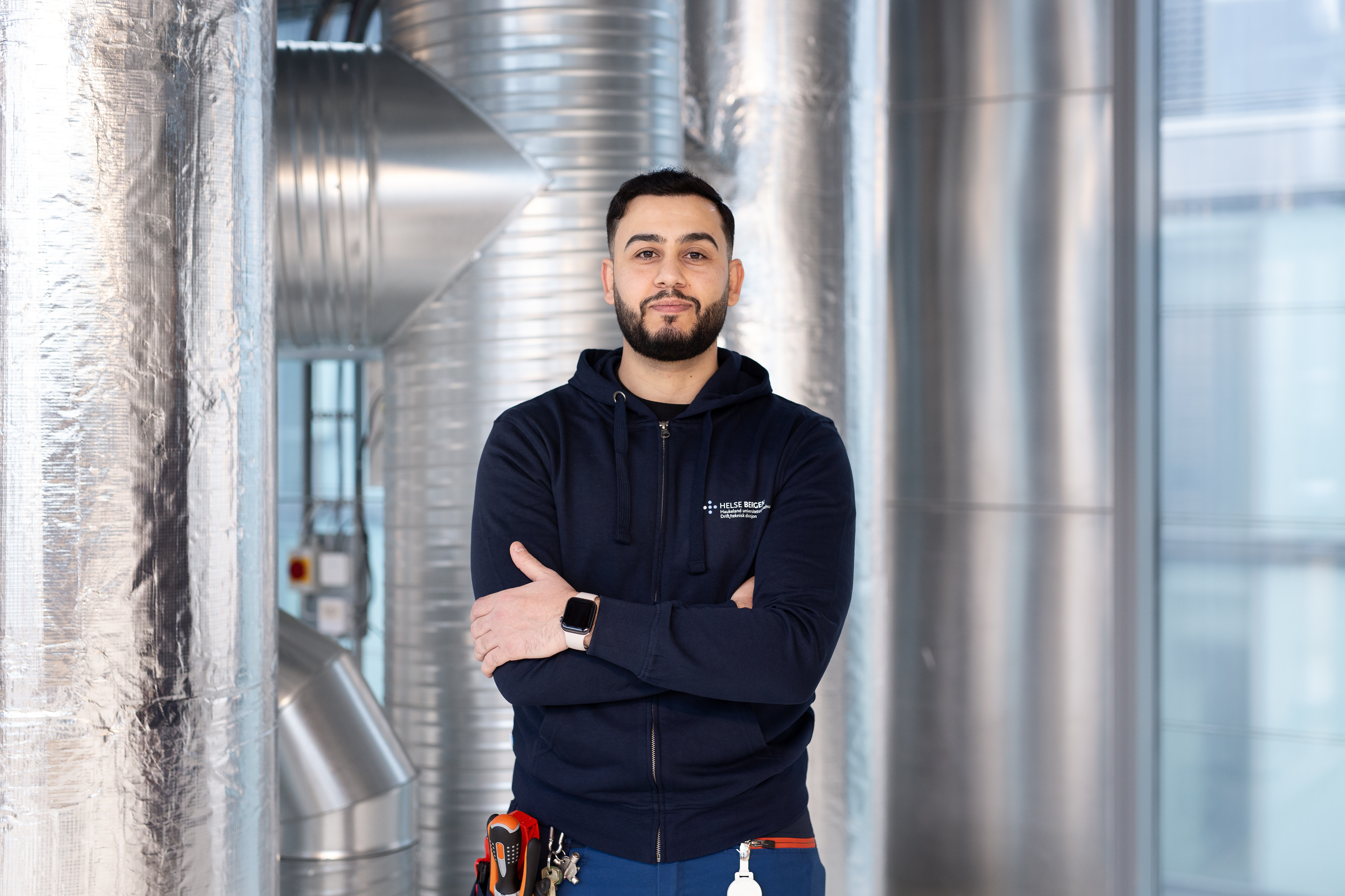 En mann står i et rom med metalliske rør