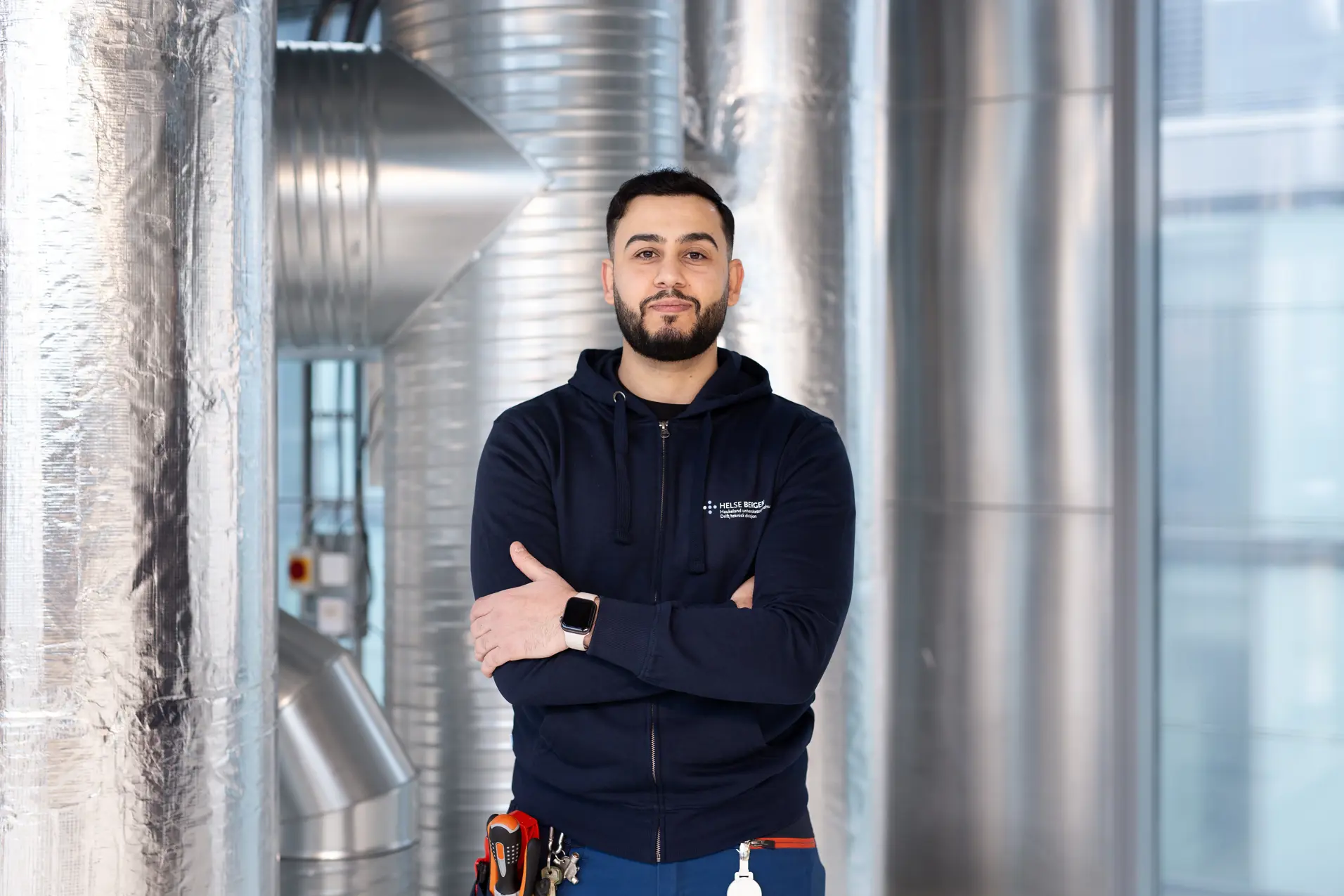 En mann står i et rom med metalliske rør