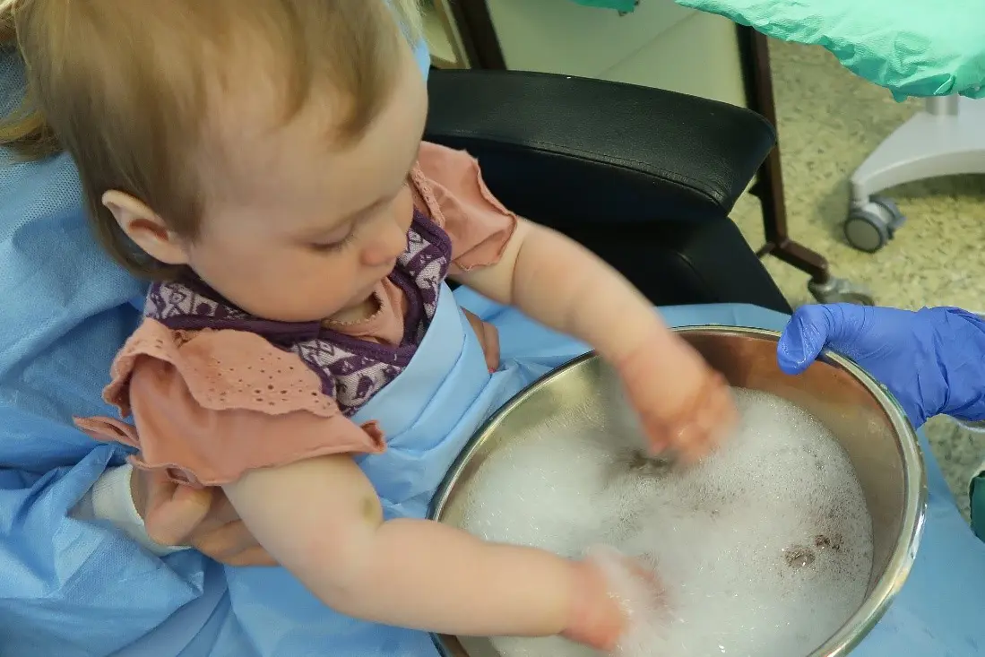 A baby playing with a bowl