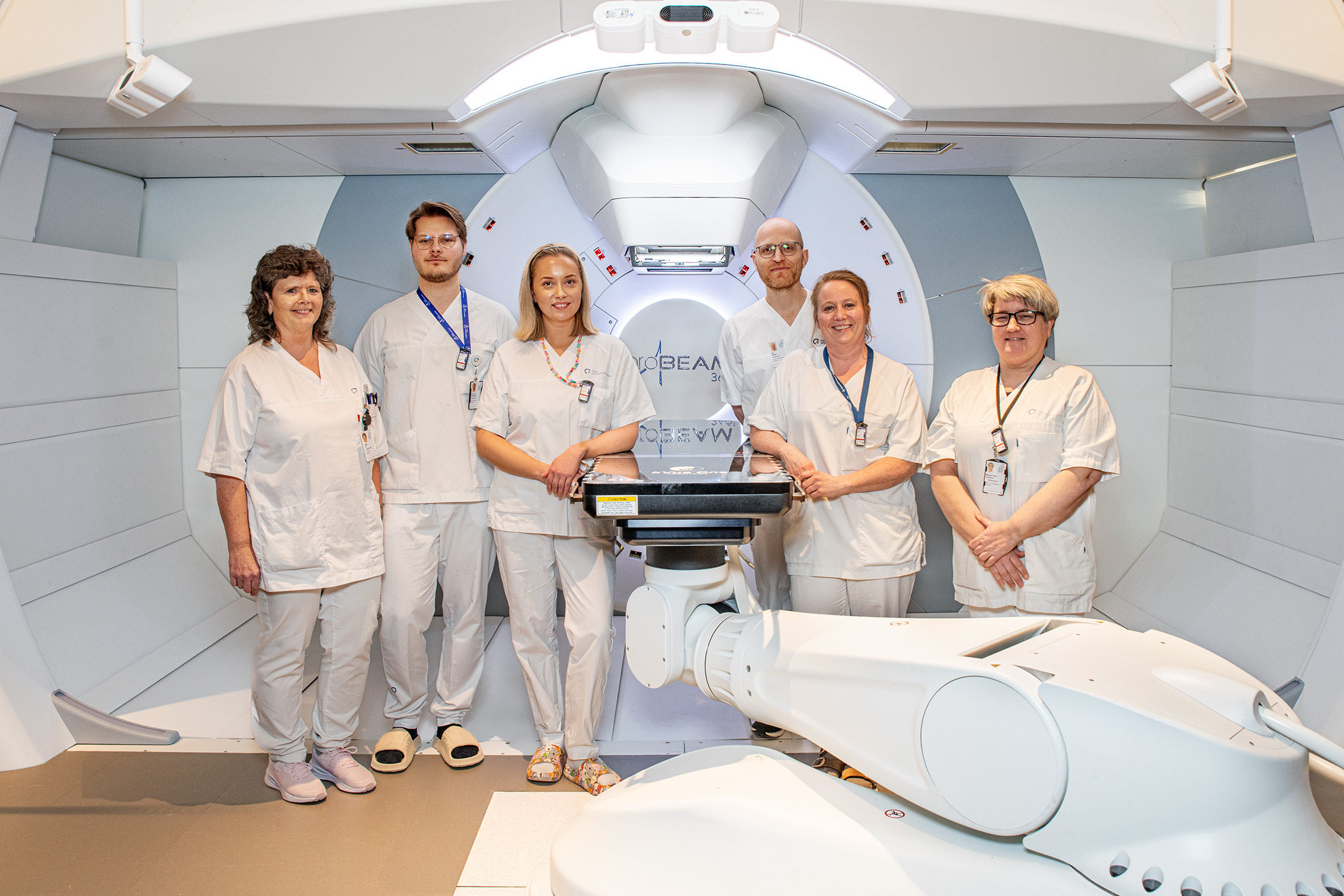 En gruppe mennesker i hvite laboratoriefrakker som står i et rom