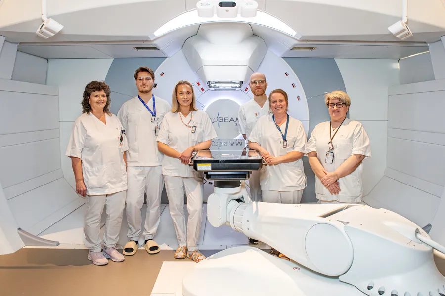 En gruppe mennesker i hvite laboratoriefrakker som står i et rom