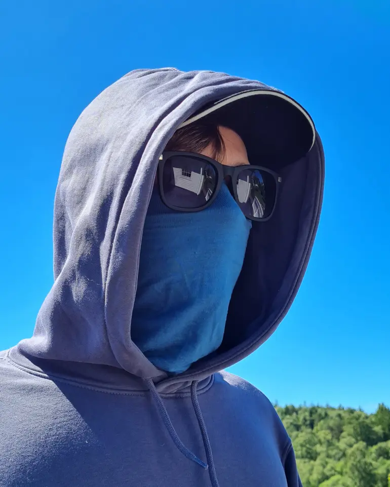 En person som har på seg hettegenser og solbriller