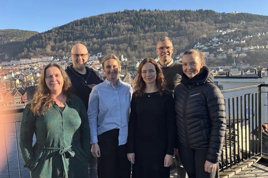 Ei gruppe menneske som poserer for eit bilde på eit tak