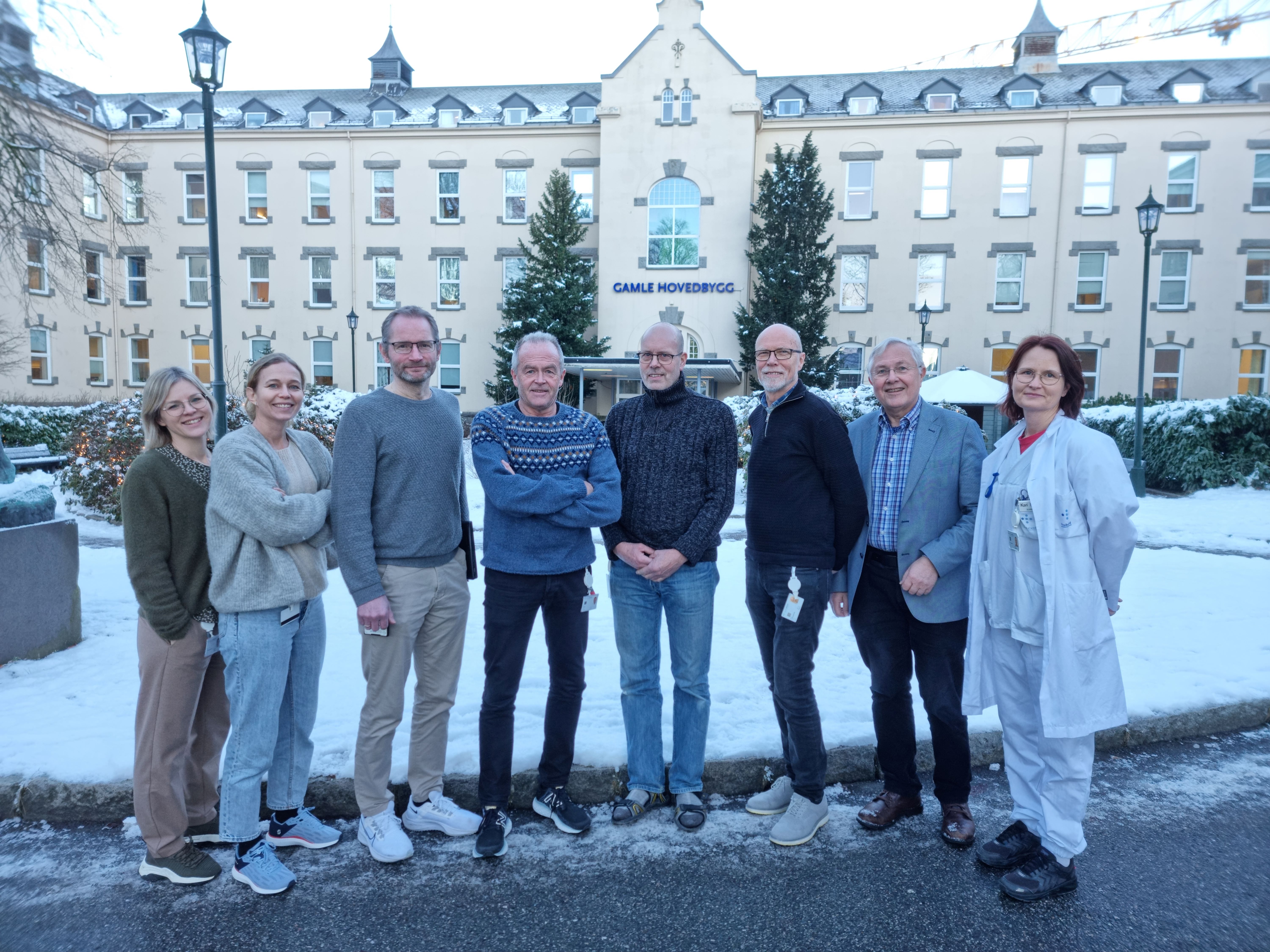 En gruppe mennesker som poserer for et bilde foran en bygning