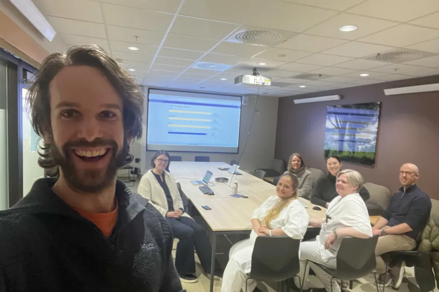 En mann som tar en selfie foran en gruppe mennesker