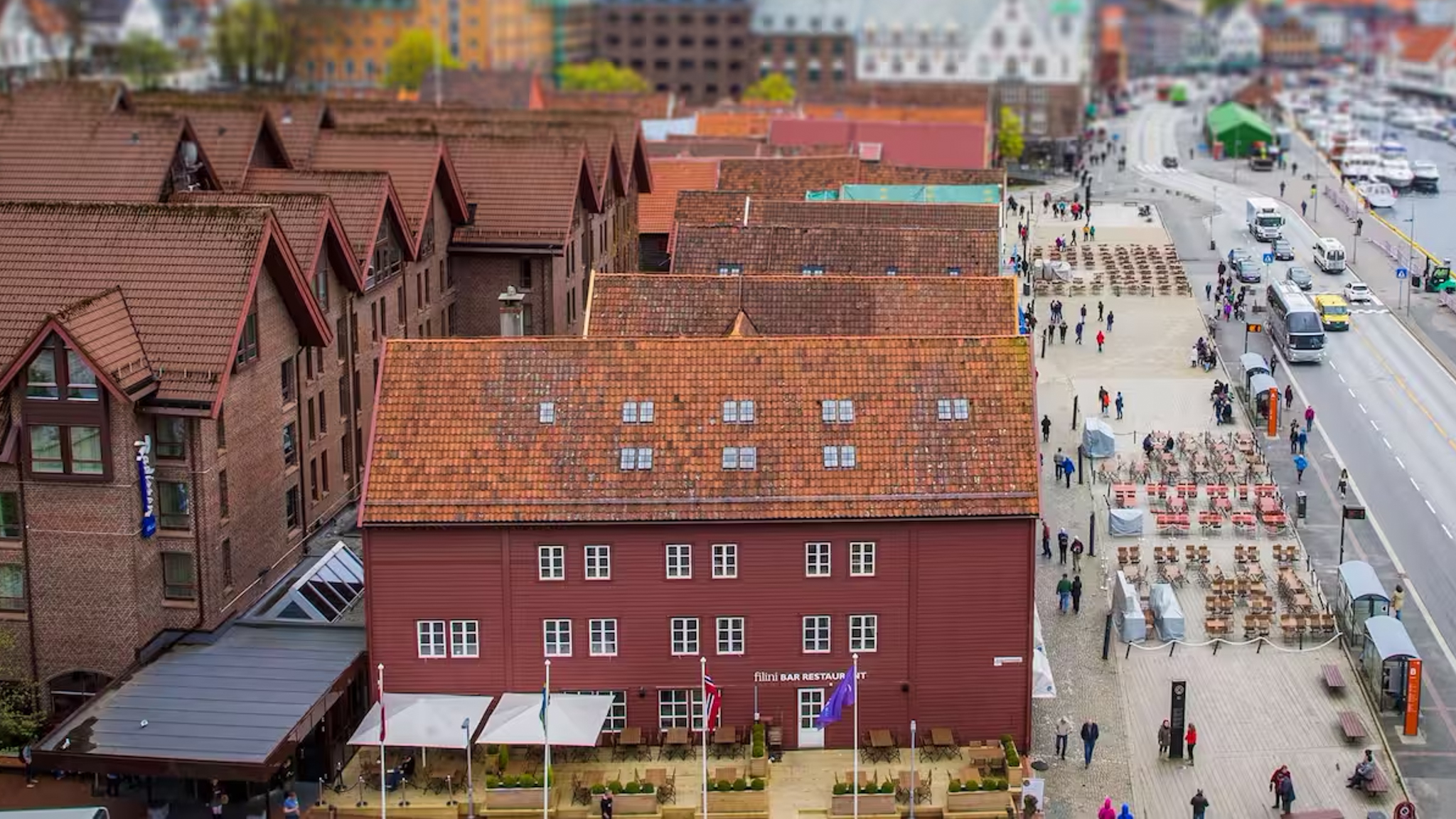 A large brick building with a street and cars in front
