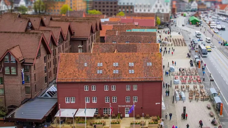 A large brick building with a street and cars in front