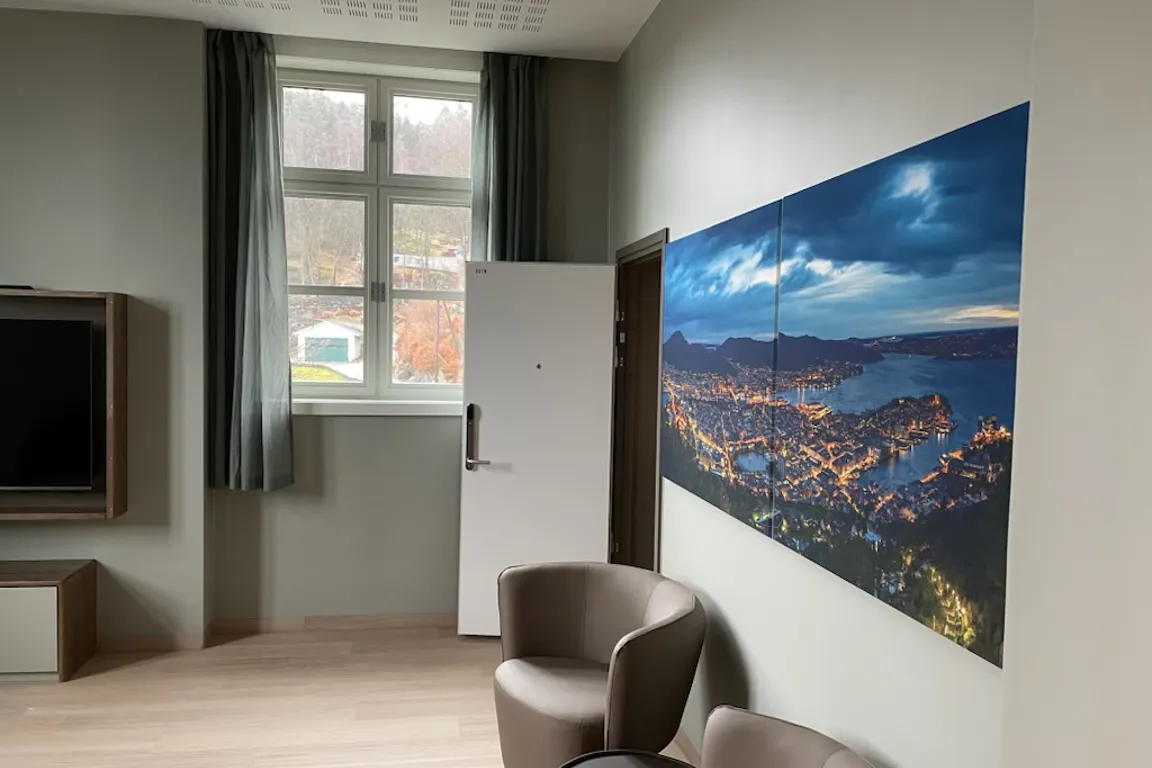 Et rom med stor skjerm og stoler