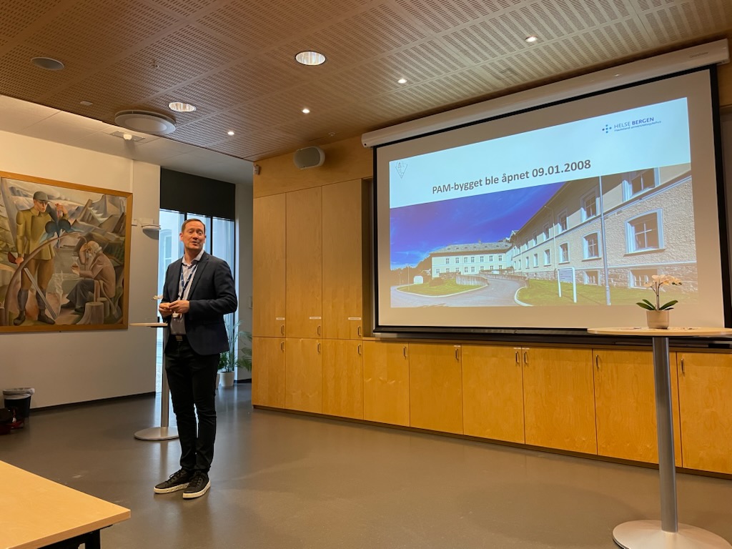 En person som står foran en stor skjerm