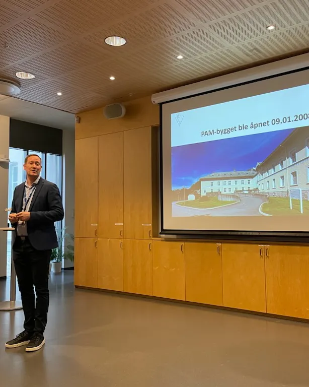 En person som står foran en stor skjerm