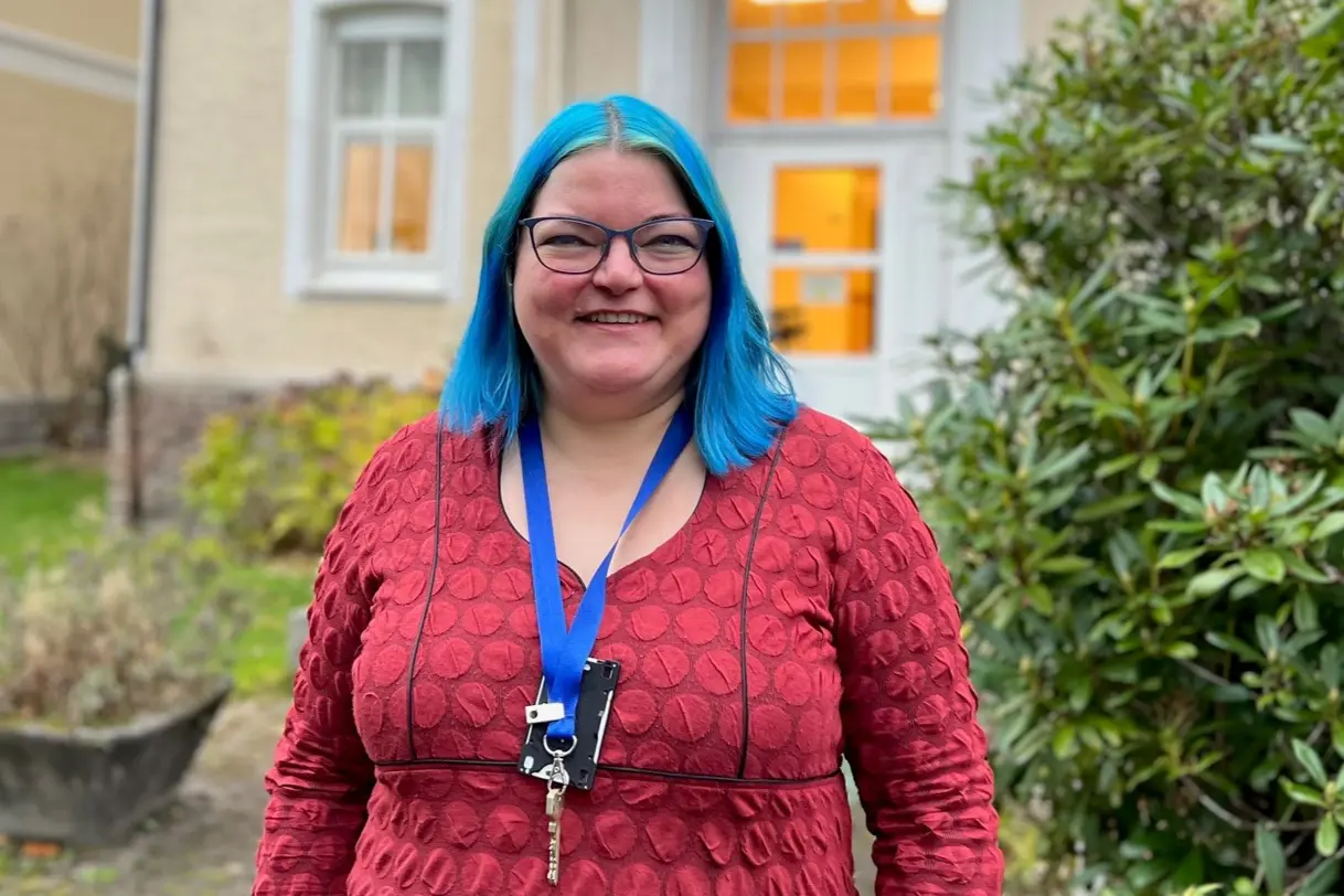 En person iført rød frakk og blått hodeskjerf