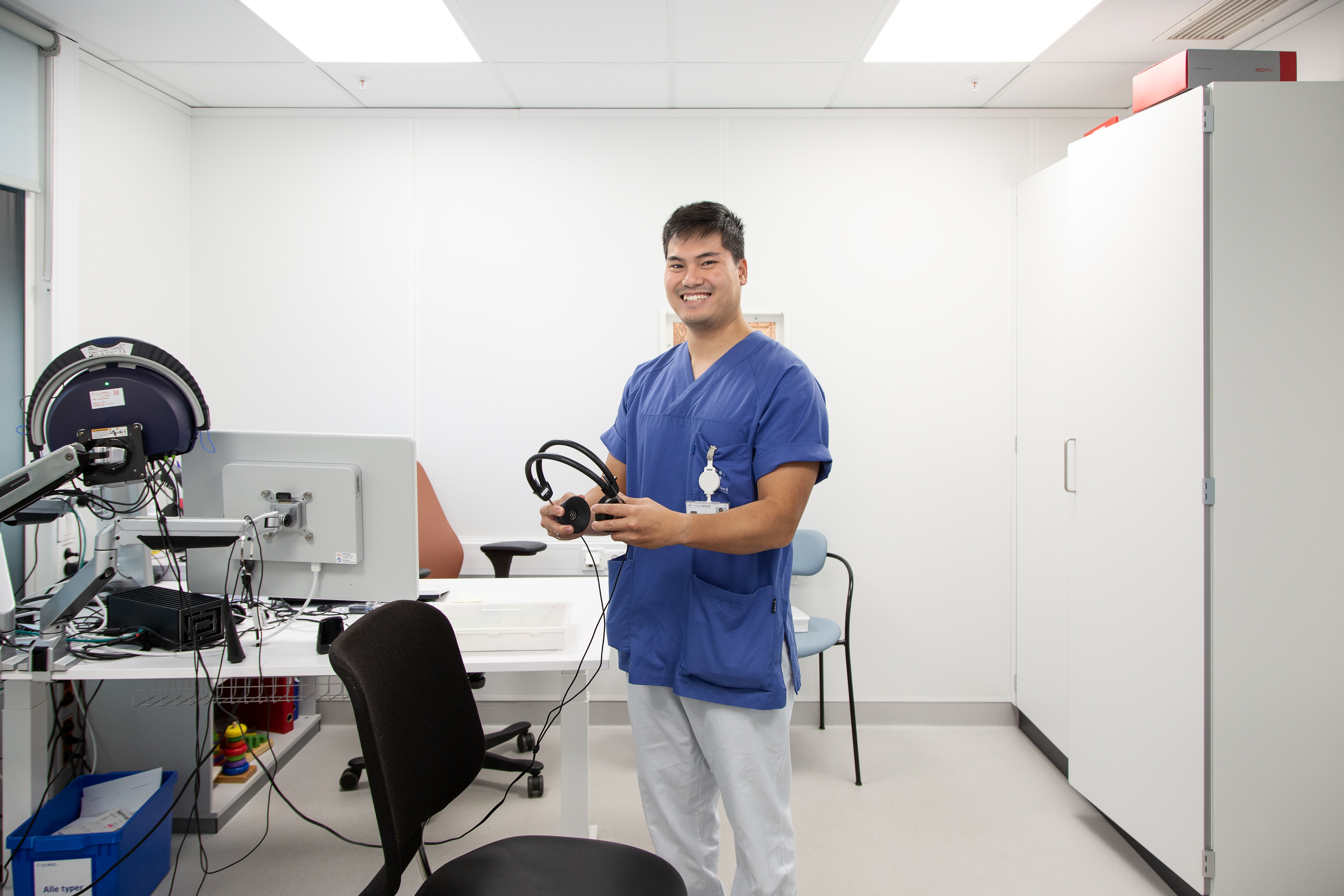 Mann i blå og hvit uniform som holder hodetelefoner