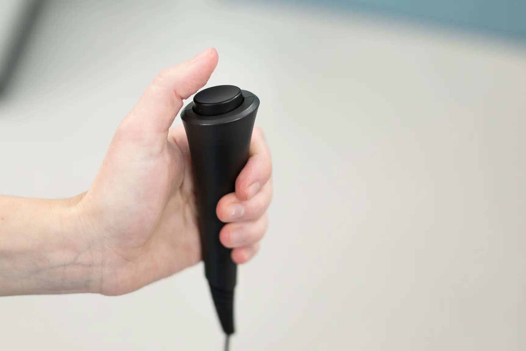 En hånd som holder i en konsoll med knapp