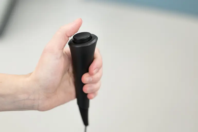 En hånd som holder i en konsoll med knapp