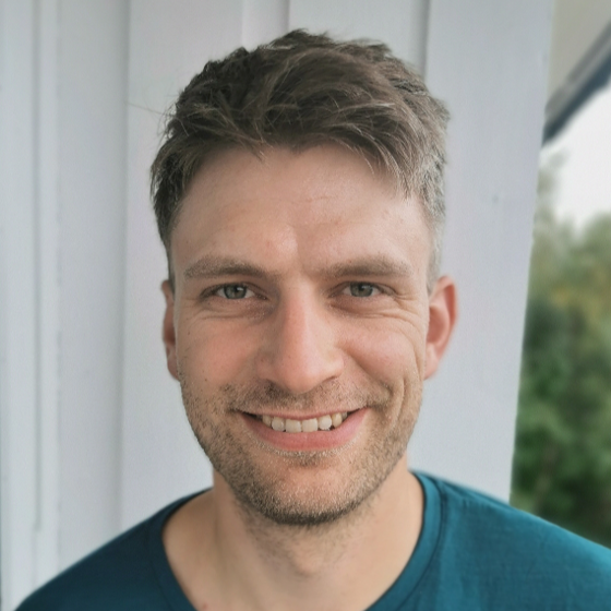 En mann som smiler til kameraet