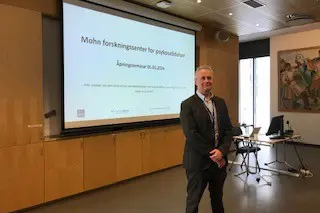 En mann som står foran en projektorskjerm