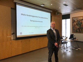 A man standing in front of a projector screen