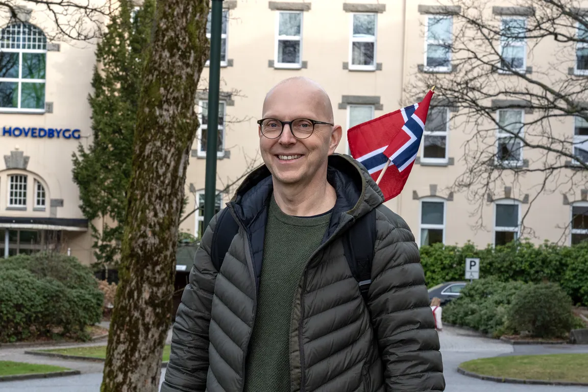 En mann som står foran en bygning med et flagg på