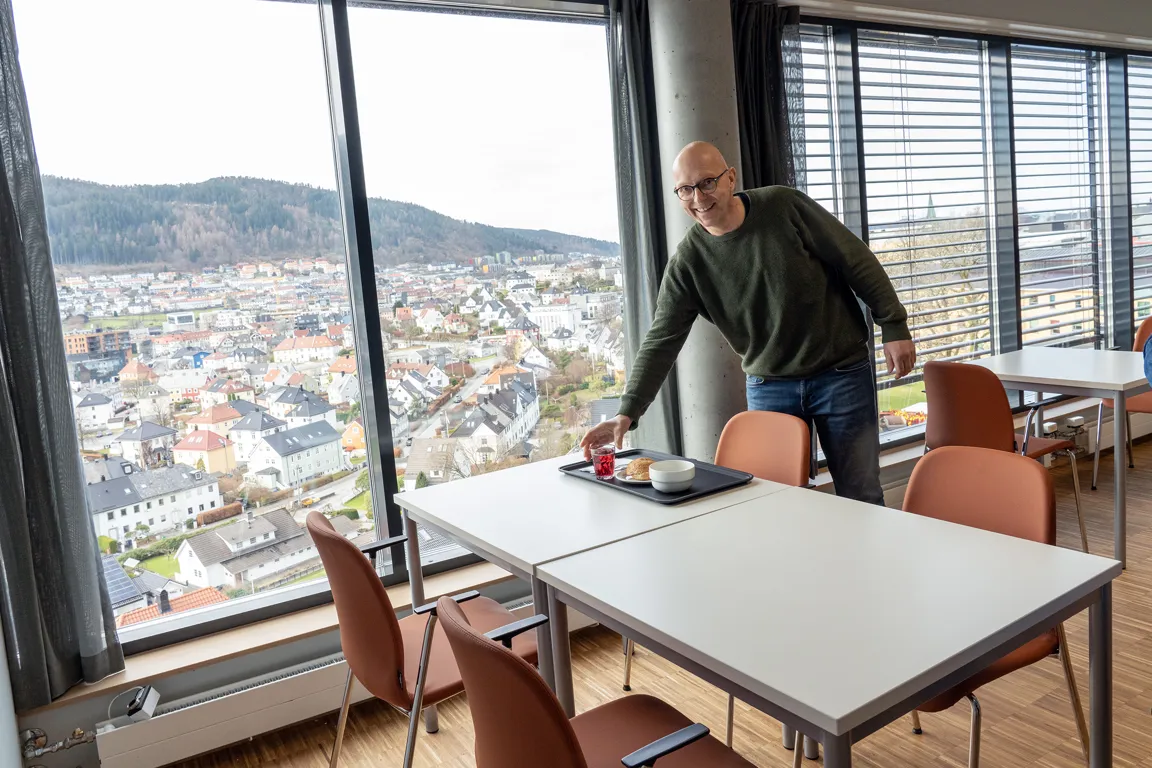 En person som står ved et bord med utsikt over en by