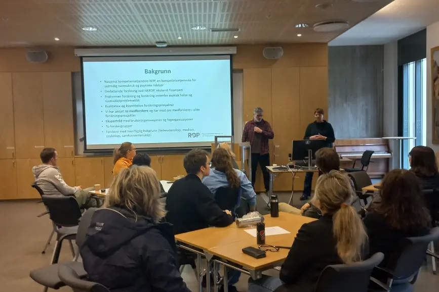 En person som holder en presentasjon for en gruppe mennesker