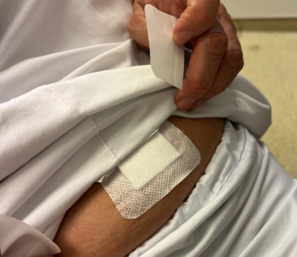 En person som setter på et plaster på magen