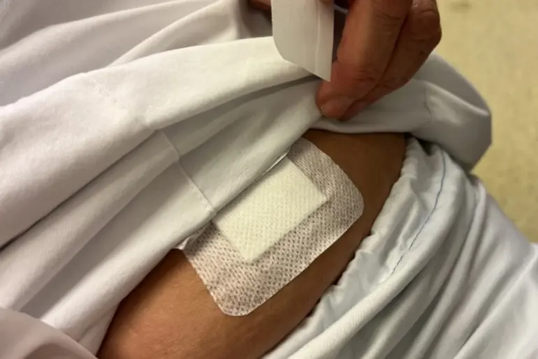 En person som setter på et plaster på magen