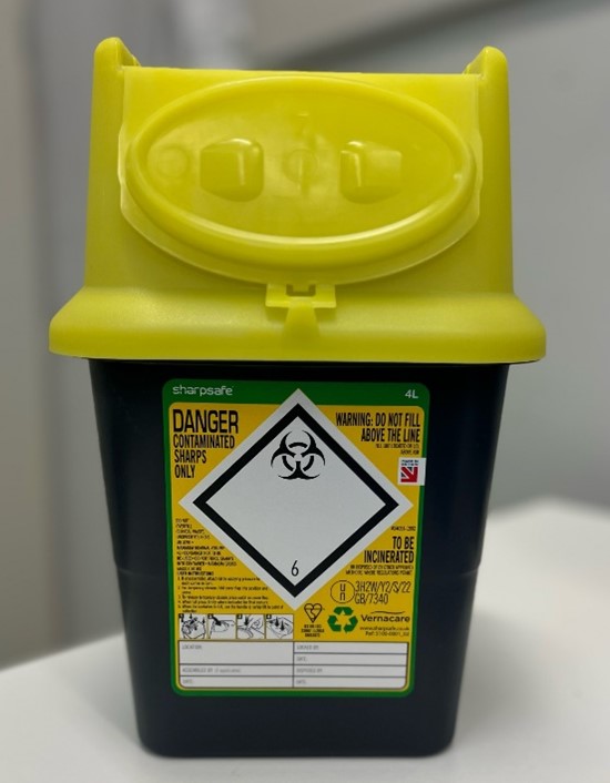 En gul kanylebøtte med en etikett