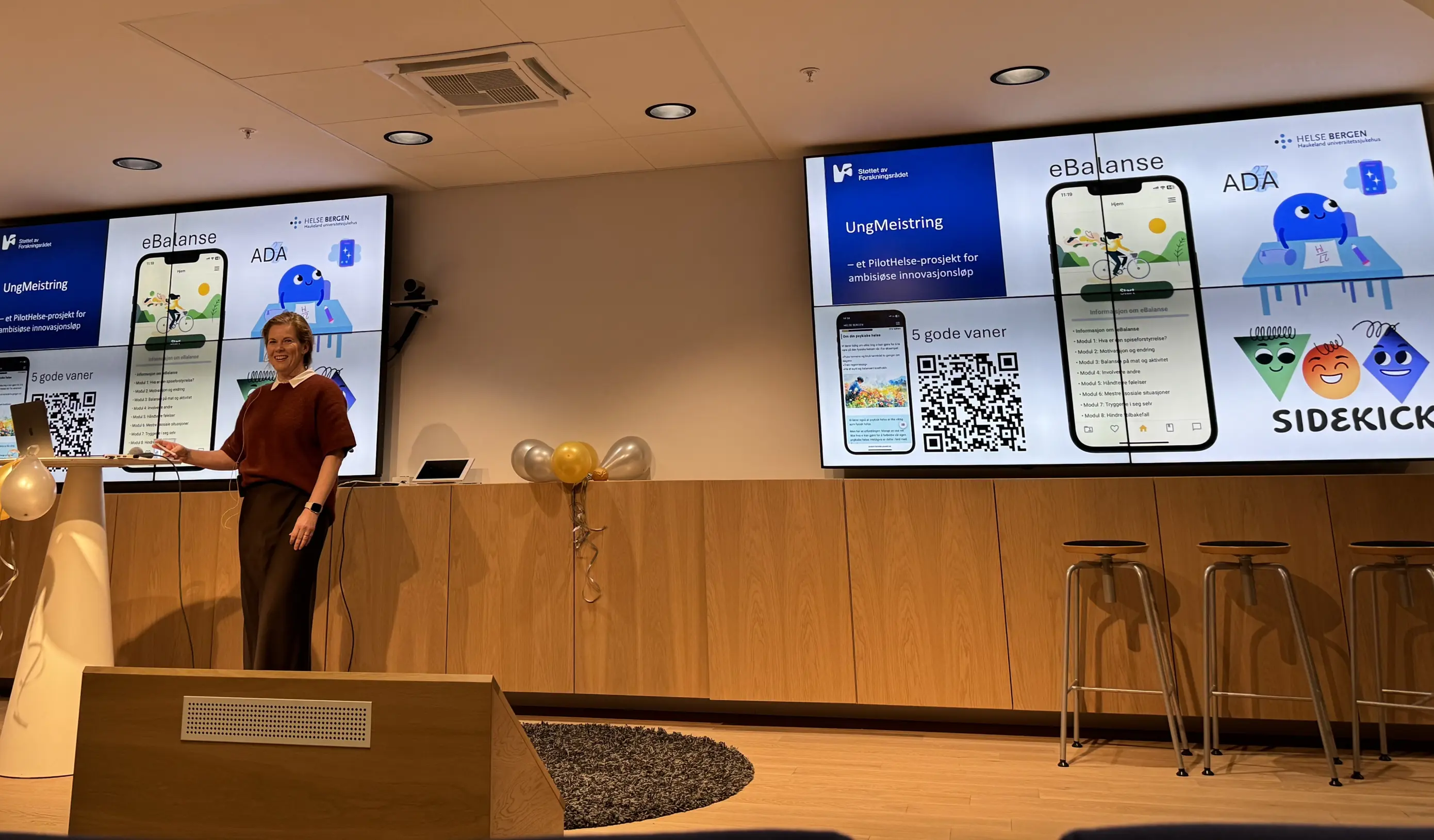 En person som står foran en talerstol med en projektorskjerm bak