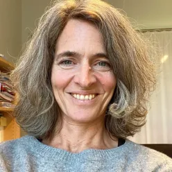 En kvinne med langt hår som smiler