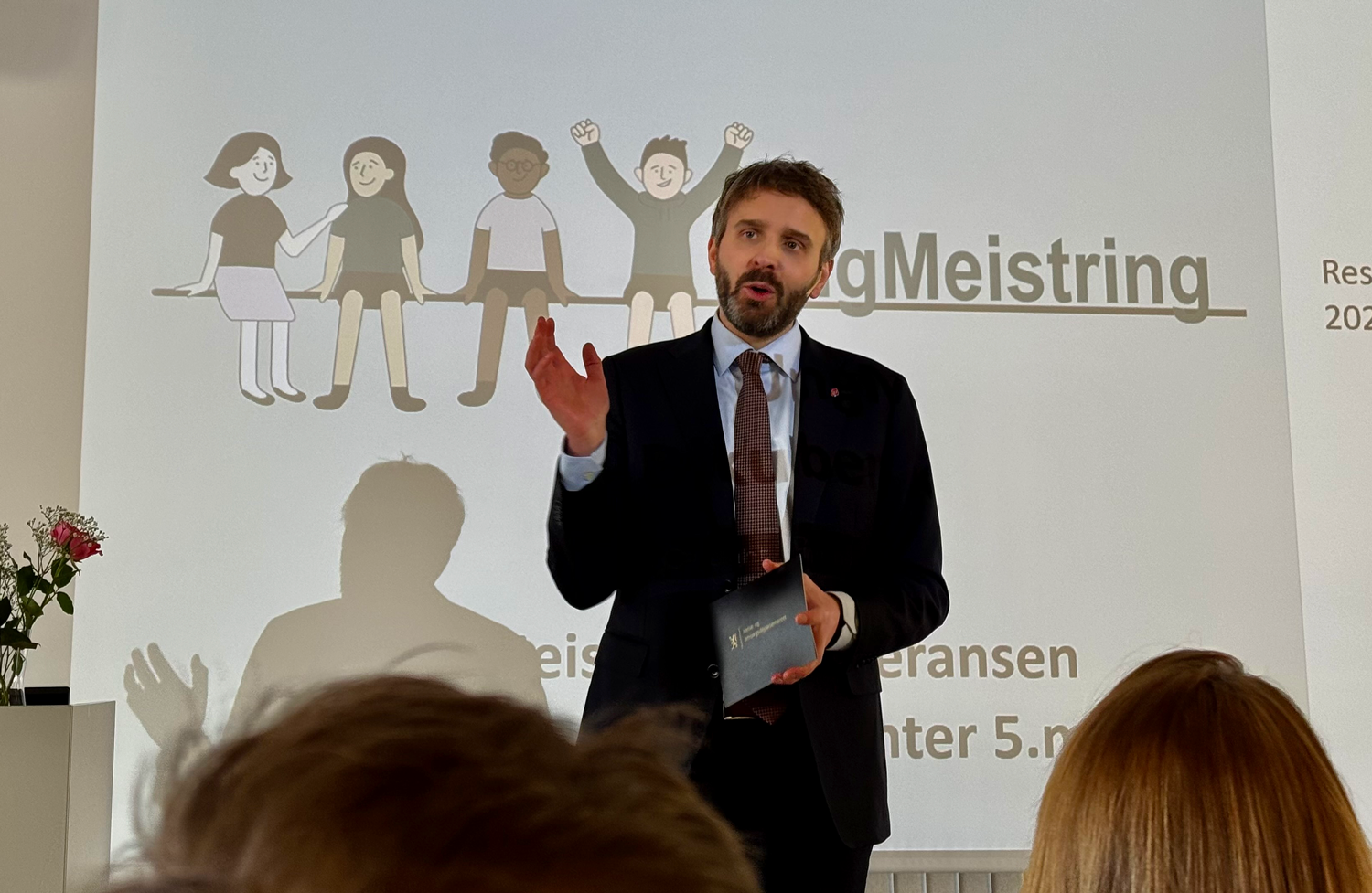 En person i dress som holder en presentasjon