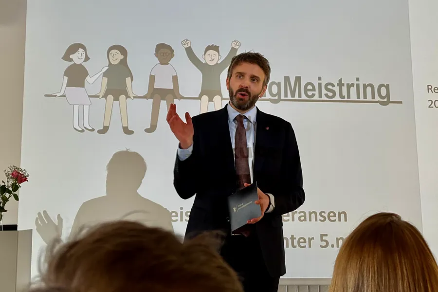 En person i dress som holder en presentasjon