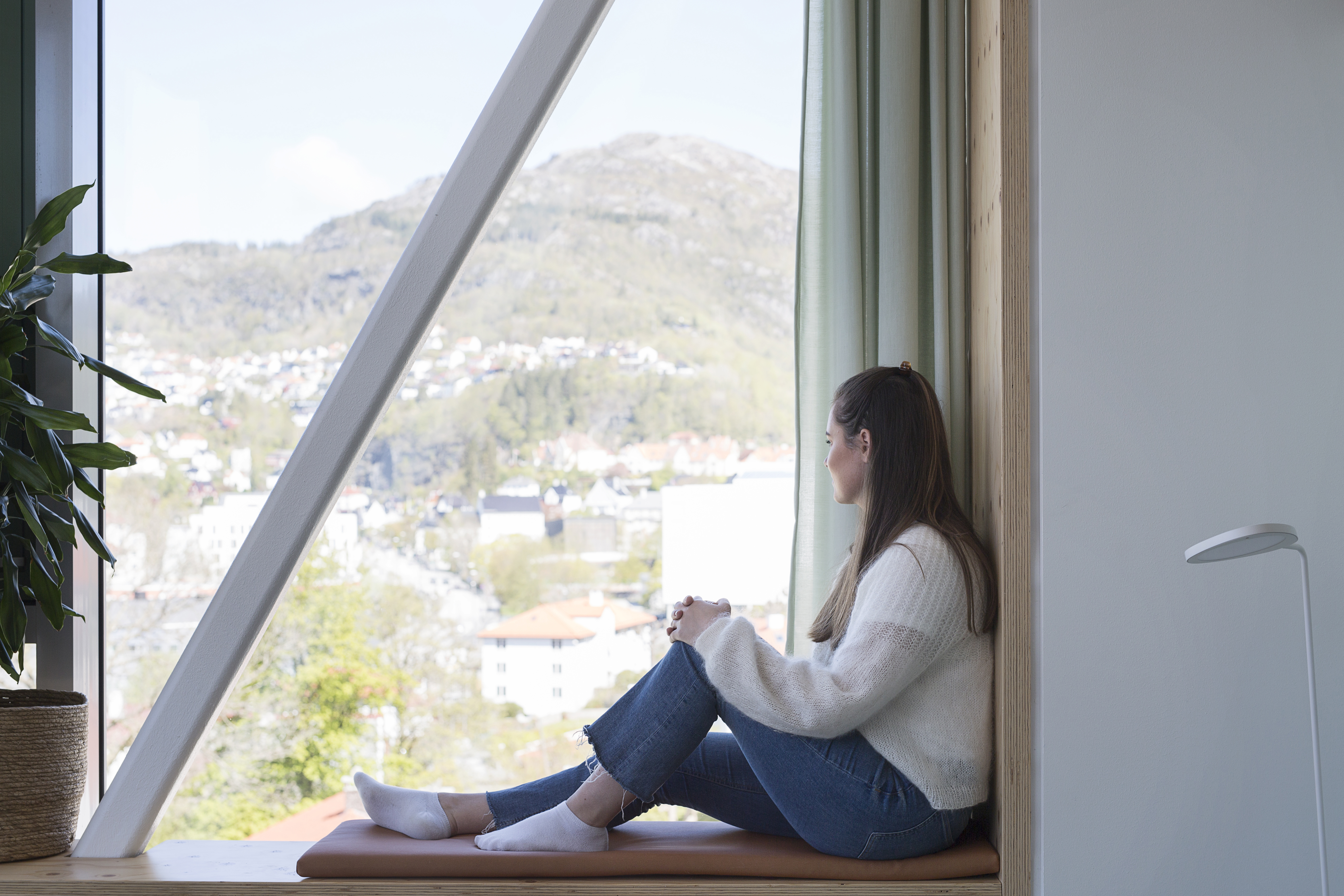 Pasient sitter i vinduskarmen