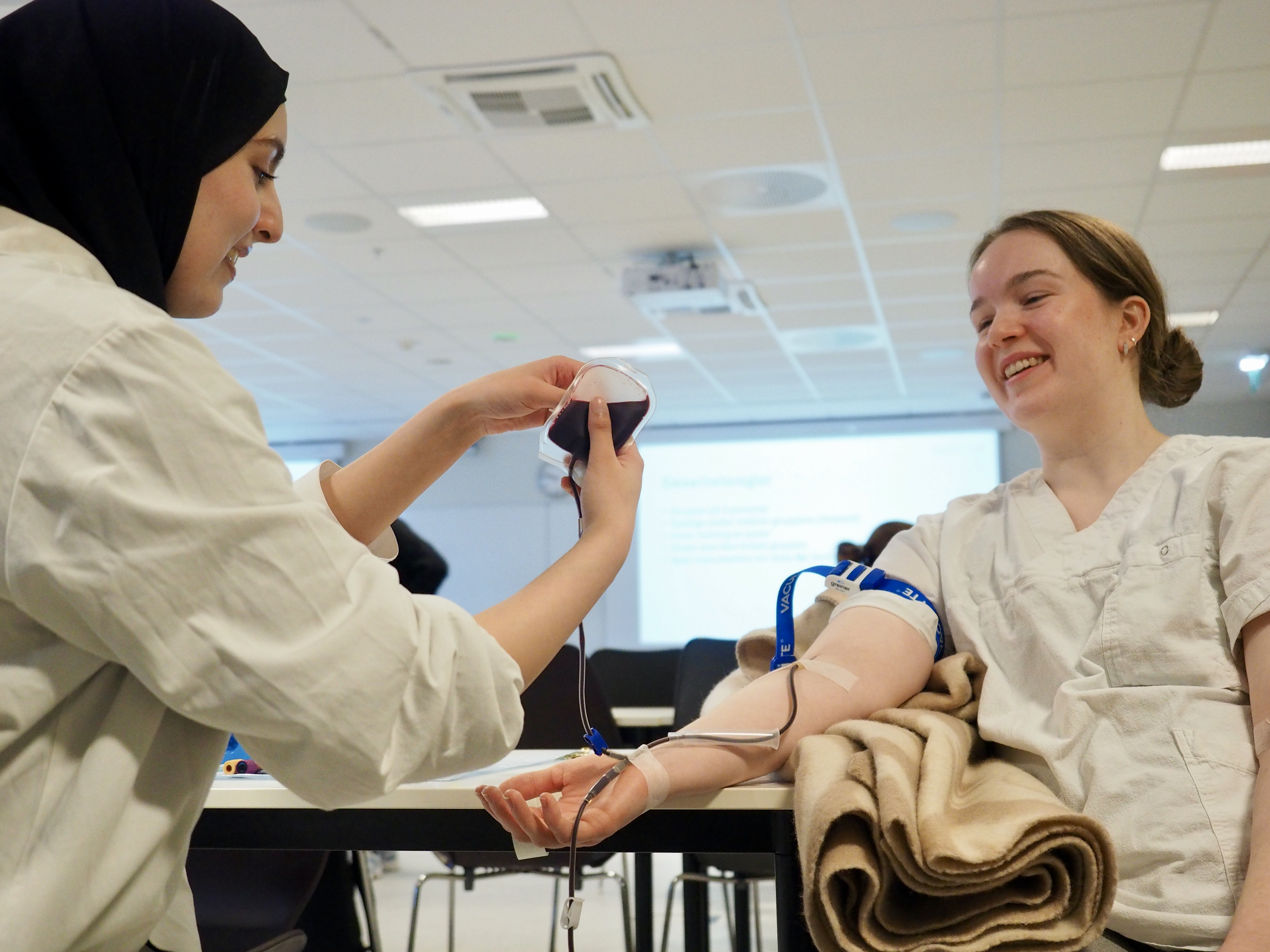 En lege som viser pasienten noe på nettbrettet